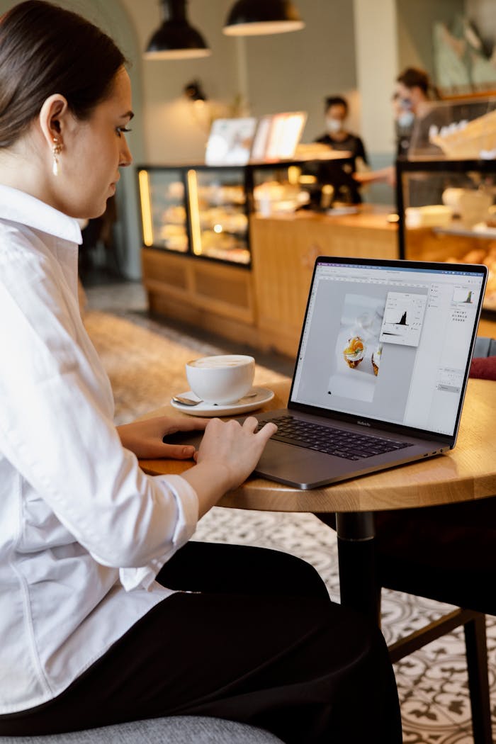 A woman working on a laptop in a stylish café, perfect for remote work themes.